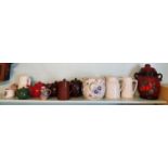 A quantity of Teapots etc. on part shelf.