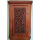 A 19th Century Oak Corner Cabinet with a highly carved door.