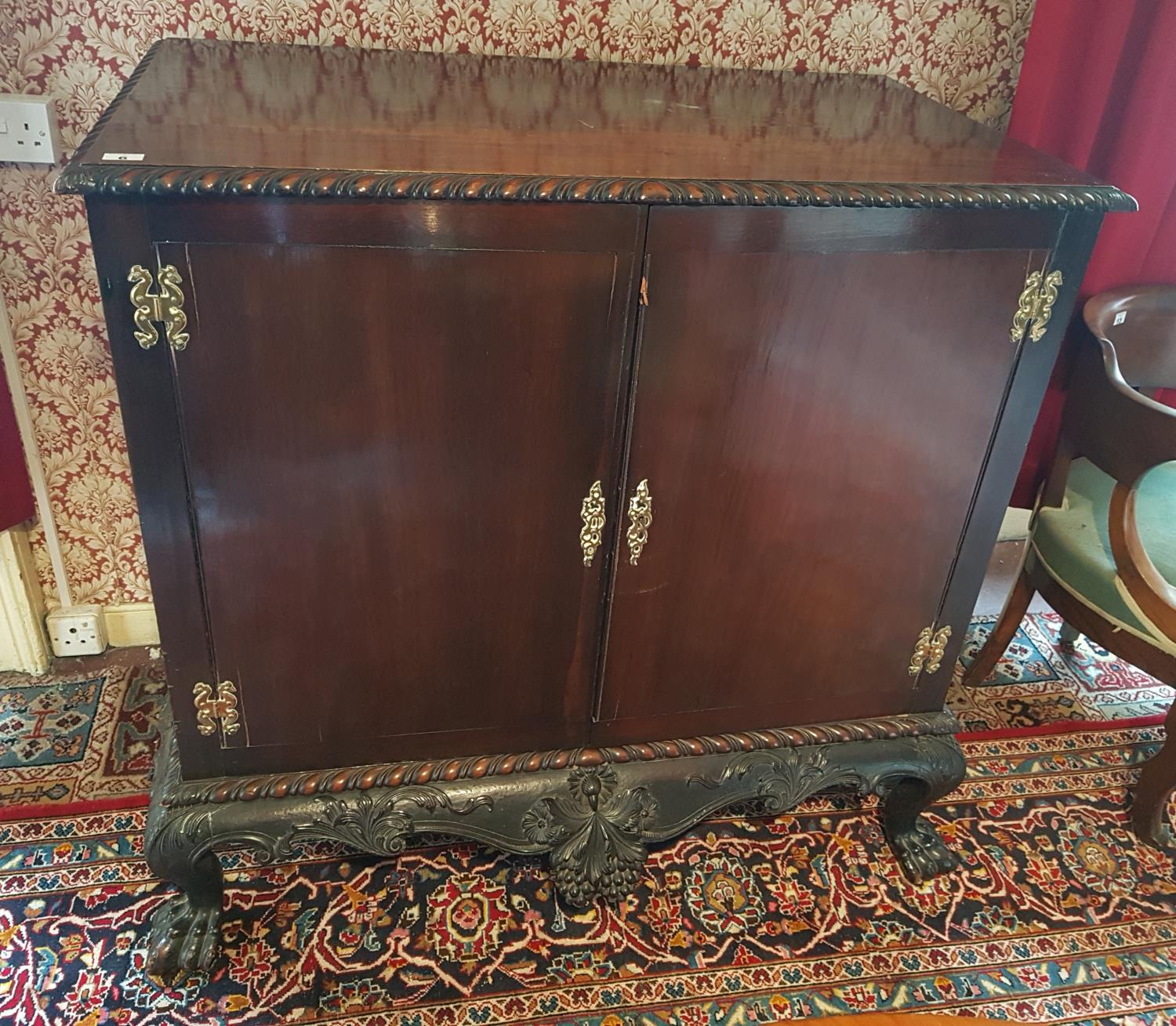 A 19c Mahogany Irish Silver Cabinet, with a highly carved freeze and hairy paw feet. W110cm X H105cm