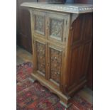 A late 19th Oak Arts and Crafts two door Side Cabinet with a highly carved front and an egg and dart