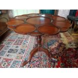 A superb 19th Century Mahogany Supper Table, the circular top with a scalloped border and carved