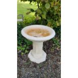 A Stone Bird Bath with columned supports.