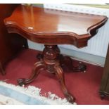 A Victorian Mahogany Serpentine fronted Foldover Card Table on quadrafoil scissors pod.