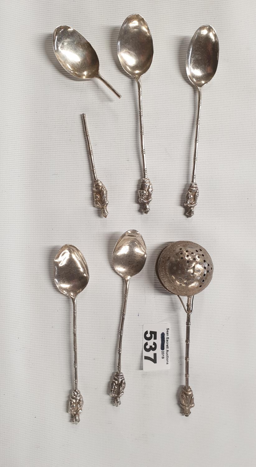 A quantity of Oriental Spoons along with a strainer, probably silver.