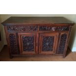 A 19th, possibly earlier, Oak Side Cabinet with twin drawer frieze over twin doors profusely