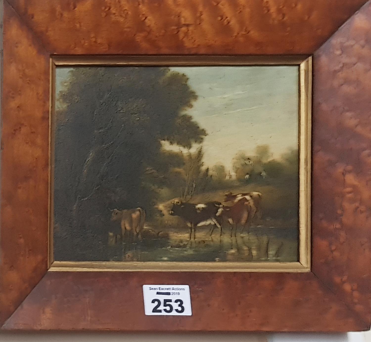 A 19th Century Oil on Panel of cattle watering. In a birds eye maple frame.