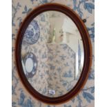 An Edwardian Mahogany Inlaid Oval Mirror with bevelled glass.