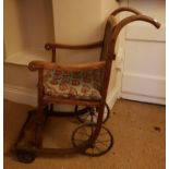 A late 19th Century Timber Wheelchair with a cane seat and back.