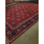 A large Red Ground Persian Tabriz Carpet with an allover floral pattern.