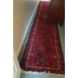 A large Red Ground Persian Runner with the medallion design.Size L 465 x W 86cms.