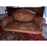 A Victorian Walnut Showframe Couch with carved outline and turned supports.
