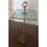 A 19th Century Brass Door Stop with a glass shelf.