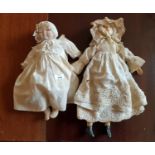 Two 19th Century Dolls in period dress with a Porcelain head and hands.