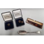 Three Cunard Line Earrings along with a silver fish knife and an amber cheroot.