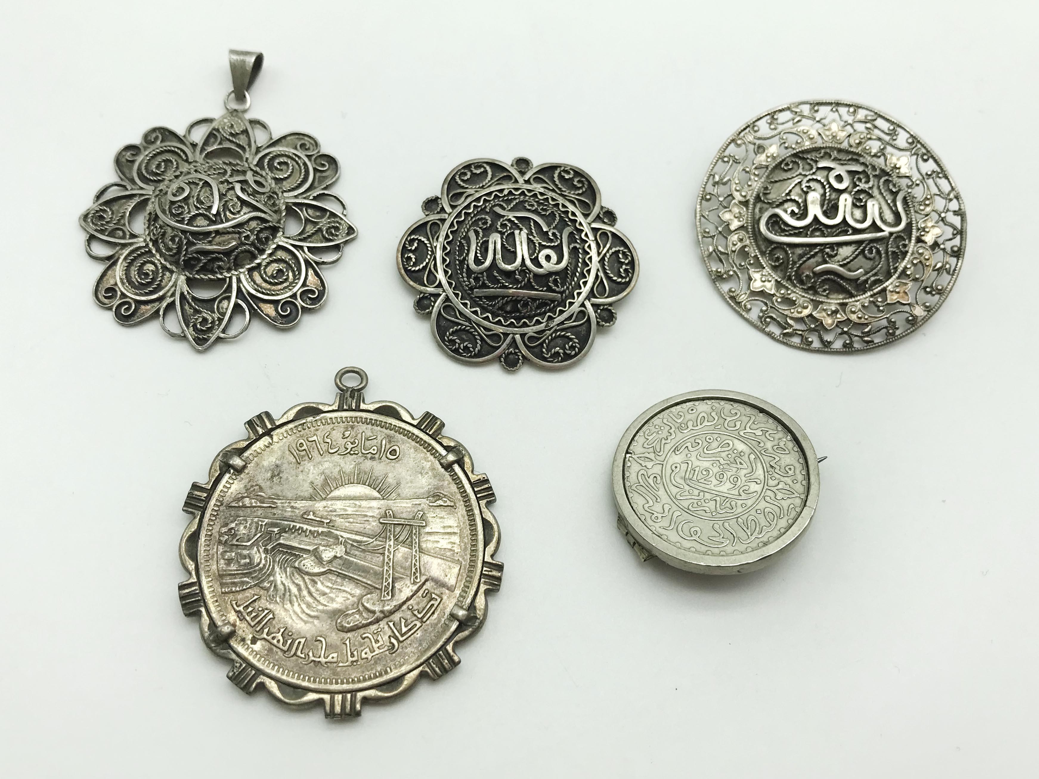 FIVE SILVER & WHITE METAL ISLAMIC BROOCHES