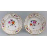 A pair of Meissen reticulated plates, creamy white ground with centre decorated in polychromed