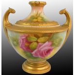 A Royal Worcester blush ivory pattern vase of Grecian urn form, with a pair of upright gilt scroll