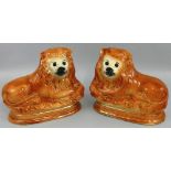 A matching pair of English Staffordshire Pottery lion figures, with glass eyes, height 25 cm, length