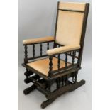 An American stained beech rocking chair, with turned bobbin supports, beige upholstery.
