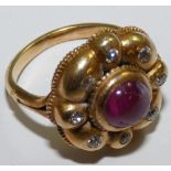 A Victorian ruby and diamond cluster ring, collet set with a cabochon stone, bordered by old cuts,