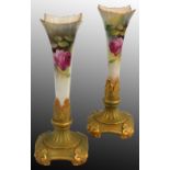 A Royal Worcester pair of blush ivory spill vases, with gilt base and rose decoration on apricot