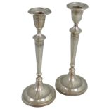 A pair of silver candlesticks, Birmingham 1914, of oval form, the urn shape sconces to a tapering