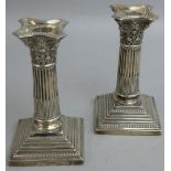 An Edwardian pair of silver Corinthian column candlesticks, Sheffield 1908, with acanthus leaf