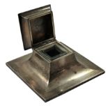 A silver inkwell, Birmingham 1926, of square capstan form with engine turned decoration, the