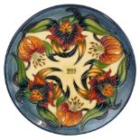 A Moorcroft pottery Annual Year plate '1999' decorated with the 'Tiger Lily' pattern, limited