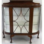 A mahogany D shape display cabinet, the central astragal door flanked by curved panels raised on