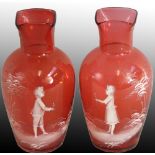 A pair of Mary Gregory style cranberry and white glass baluster vases, one with a boy holding