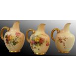 A Royal Worcester blush ivory trio of flat-back jugs, each with gold gilt and floral decoration on