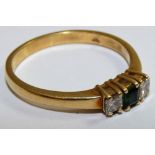 An 18ct gold emerald and diamond three stone ring, claw set with a square stone flanked by