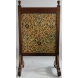 A late Victorian oak glazed fire screen, the front opening to reveal a tapestry panel, glazed