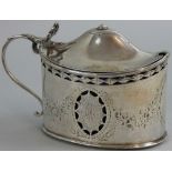 A George III silver mustard pot, London 1787, of oval form with pierced and floral engraved