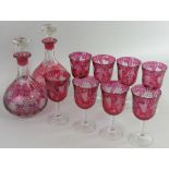 A pair of cranberry glass carafes, wheel cut decoration of grapes and vines, height 26 cm,