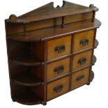 An Edwardian mahogany wall cabinet, composed of six drawers, flanked by open shelves, length 54