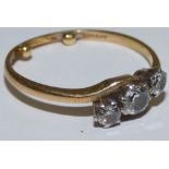 An 18ct gold three stone diamond ring, claw set with an old cut stone, flanked by smaller stones,