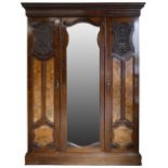A Victorian mahogany triple wardrobe, the central bevelled mirror door flanked by panelled doors