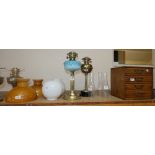Four brass oil lamps including glass shades and chimneys, small four drawer chest (5)