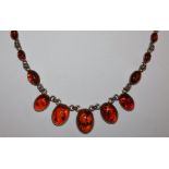 A silver and amber necklace collet set with cabochon stones