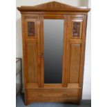 An Edwardian single wardrobe, central mirror flanked by a pair of carved panels with single