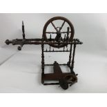 A 20th century French small fruitwood spinning wheel, with turned supports, in need of