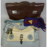 A vintage leather bag with initials A.C. to the front, with contents including a scarf with triple
