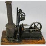 A stationary hot air engine by G. C. & Co. N., mounted on a wooden plinth measuring 12 cm x 24 cm.