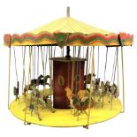 A revolving circa 1930's wooden carousel, painted in yellow and red featuring horse and chicken