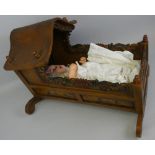 A composition baby doll by Britoy, 50 cm tall together with a hand painted wooden cot (2)