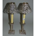 An Edwardian silver pair of Corinthian column candlesticks Sheffield 1907 with spring loaded