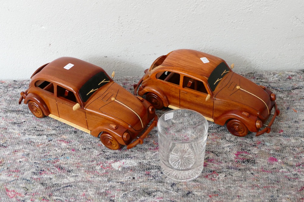 A pair of wooden models of Volkswagen Beetles, together with a presentation glass tumbler