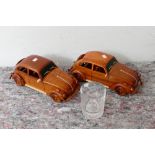 A pair of wooden models of Volkswagen Beetles, together with a presentation glass tumbler